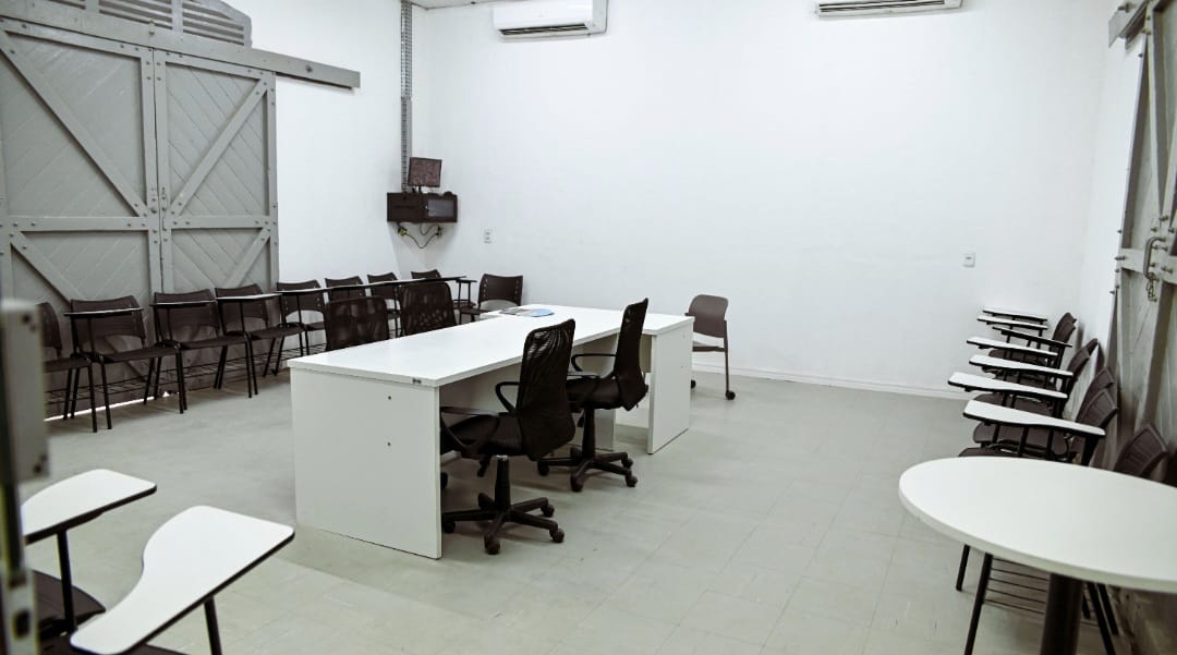 Sala de reunião com mesa central e cadeiras na Estação Tecnológica