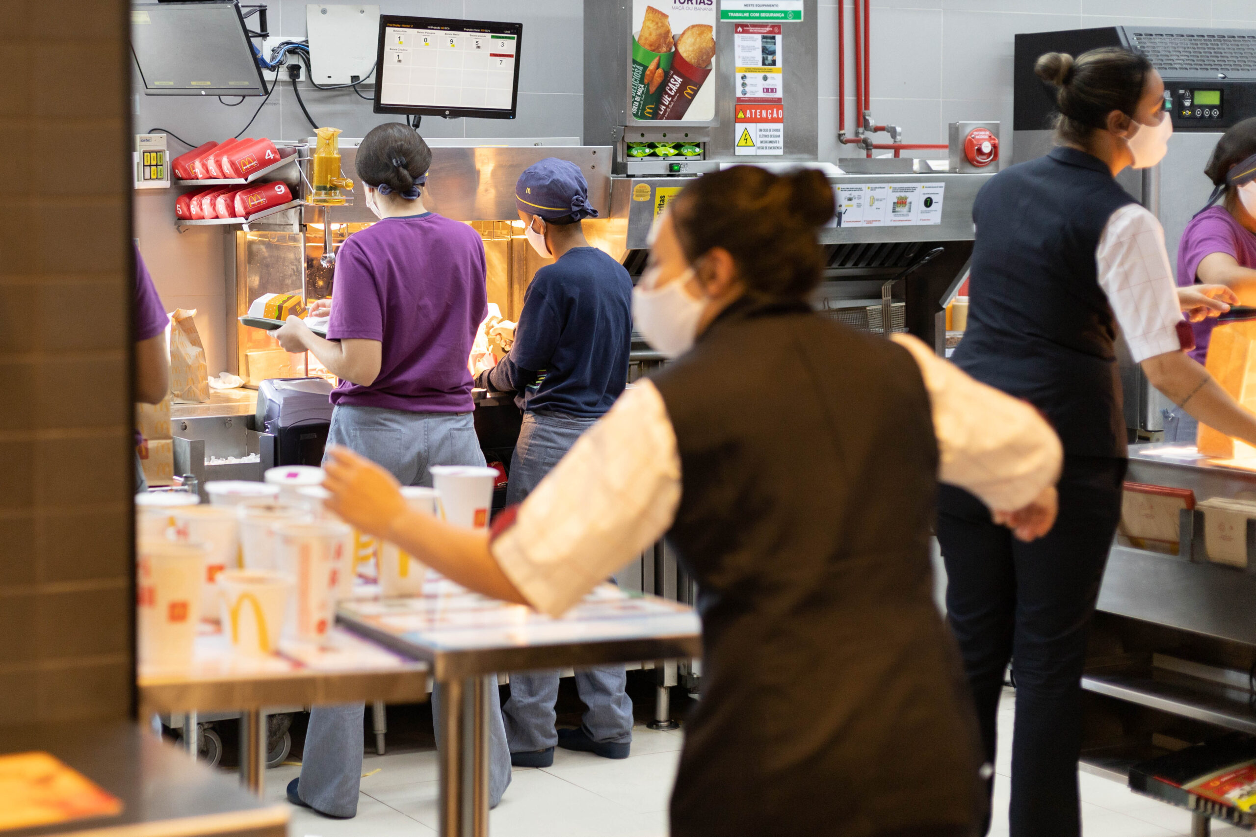 Trabalhadores na área de preparo de um restaurante McDonald’s